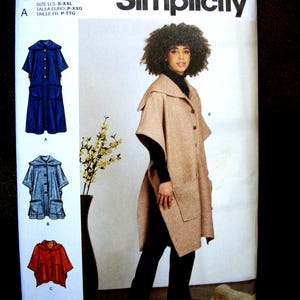 May include: Simplicity sewing pattern S9649 featuring a woman wearing a tan cape with large pockets. The pattern includes illustrations of capes in blue, gray, and red. The text "easy-to-sew" and "Designed and printed in USA" are also visible.