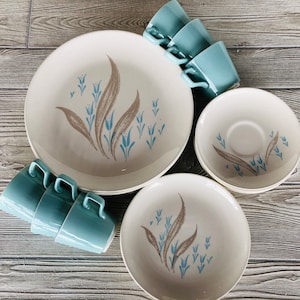 May include: A set of vintage blue and white floral patterned dinnerware. The set includes a large platter, two smaller plates, and four cups and saucers.