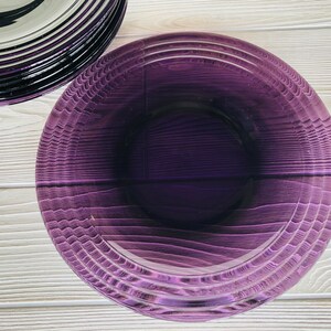 May include: A purple glass bowl with a textured, rippled design. The bowl is empty and has a glossy finish.