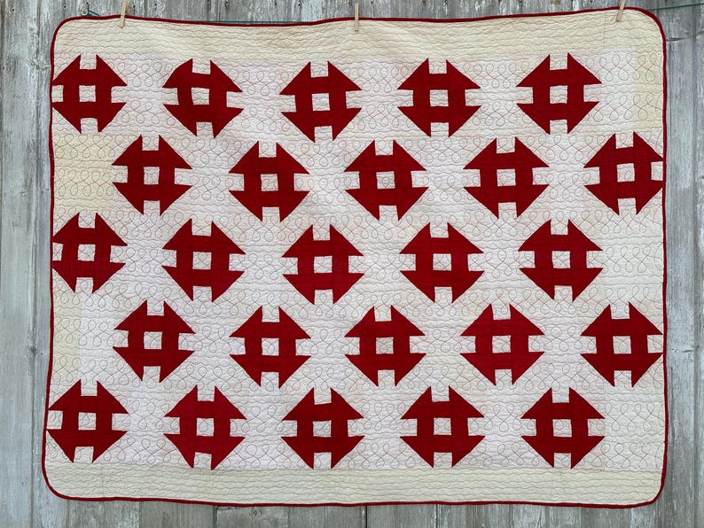 Peut inclure: Une courtepointe faite &agrave; la main avec un motif r&eacute;p&eacute;titif de formes g&eacute;om&eacute;triques rouges sur un fond cr&egrave;me. La courtepointe a une bordure rouge. Le design est sym&eacute;trique et les coutures sont visibles. Fabriqu&eacute; en coton.