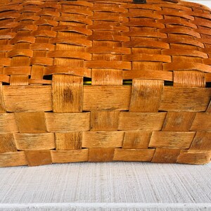 Puede incluir: Una cesta rectangular tejida de color marr&oacute;n. La cesta est&aacute; hecha de materiales naturales y tiene un aspecto r&uacute;stico.