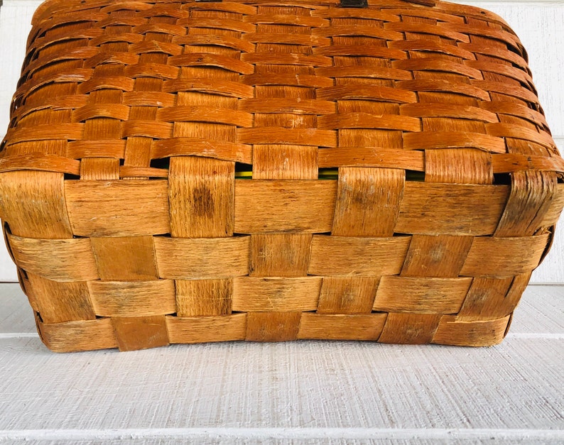 Puede incluir: Una cesta rectangular tejida de color marr&oacute;n. La cesta est&aacute; hecha de materiales naturales y tiene un aspecto r&uacute;stico.