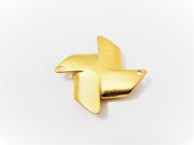 May include: Gold-colored metal windmill charm with two holes for attaching to jewelry or other crafts.