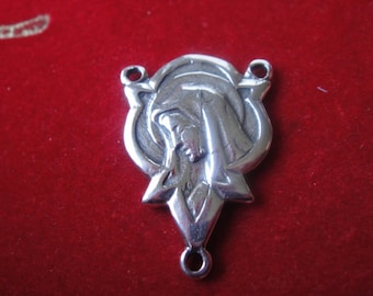 May include: Silver-toned metal charm featuring a detailed image of the Virgin Mary. The charm has two loops for attaching to a necklace or bracelet.