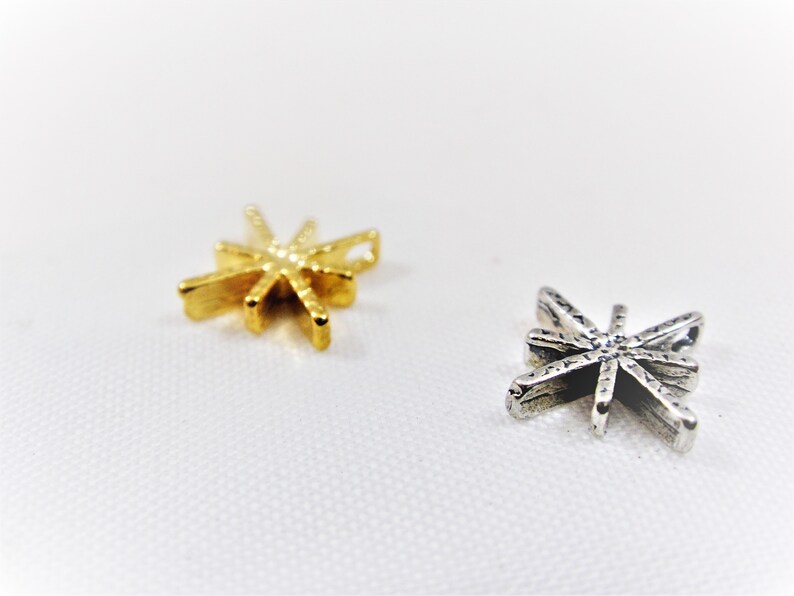 May include: Two star-shaped charms, one gold and one silver, with a textured surface.