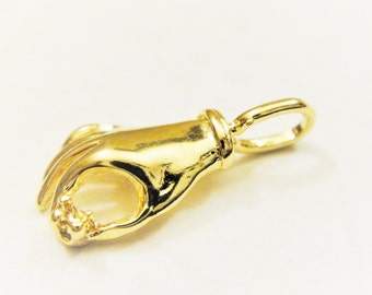 Könnte beinhalten: Ein goldfarbener Anhänger in Form einer Hand, die das "OK"-Zeichen macht. Der Anhänger hat oben eine Schlaufe zum Anbringen an einer Halskette oder einem Armband.
