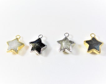 May include: Four star-shaped pendants with gold and silver settings. Two pendants feature a white stone, and two pendants feature a black stone.