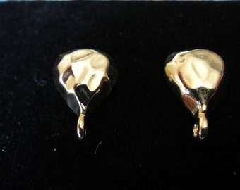 May include: A pair of gold-coloured metal earring charms in the shape of a teardrop with a textured surface.