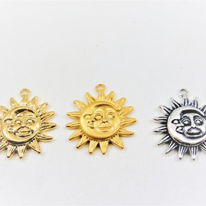 May include: Three sun charms with a face on them. The charms are gold, silver, and antique silver.