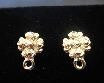 May include: A pair of gold-toned earrings with a cross-shaped design and a small loop hanging from the bottom.