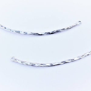 May include: Two silver hammered metal connectors with loops at each end. These connectors are perfect for adding a unique touch to jewelry making projects.