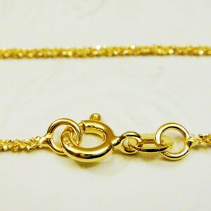 May include: A gold chain necklace with a delicate, twisted design. The chain is secured with a lobster clasp.
