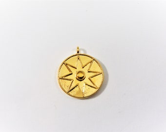 May include: Gold pendant with a circular design featuring a raised eight-pointed star with a small circle in the center.