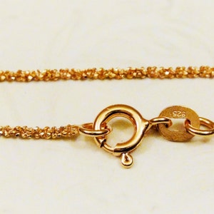 Puede incluir: Un collar de cadena de oro con cierre de mosquet&oacute;n. La cadena est&aacute; hecha de peque&ntilde;os eslabones redondos que est&aacute;n estrechamente entrelazados. La cadena est&aacute; estampada con 925.