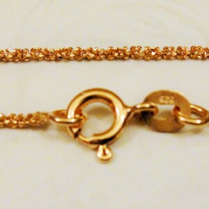 Puede incluir: Un collar de cadena de oro con cierre de mosquet&oacute;n. La cadena est&aacute; hecha de eslabones peque&ntilde;os y estrechamente tejidos.