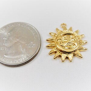 May include: Gold-toned sun charm pendant with a face and rays. The charm is about the size of a US quarter.