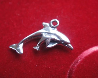 Op de afbeelding: Een zilveren dolfijnbedel met een lus om aan een ketting of armband te bevestigen.