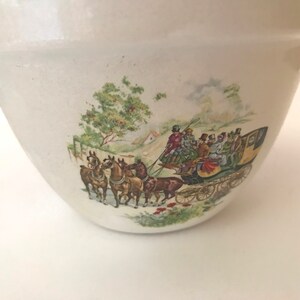 May include: A white ceramic mixing bowl with a vintage design featuring a horse-drawn carriage with passengers and a green tree in the background.