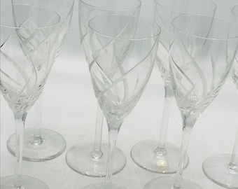 May include: Set of six clear glass wine glasses with a delicate etched design. The glasses have a long stem and a round bowl.