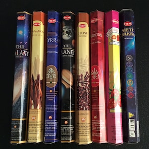 May include: A set of ten incense sticks with colorful packaging. The packaging features images of planets, stars, flowers, and a clove. The packaging also includes the text "HEM" and "INCENSE".