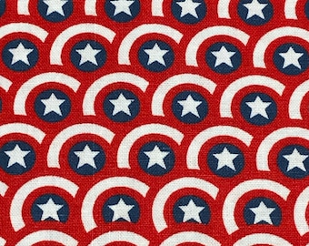 May include: Red and white fabric with a repeating pattern of blue circles containing white stars. The circles are arranged in a wave-like pattern.