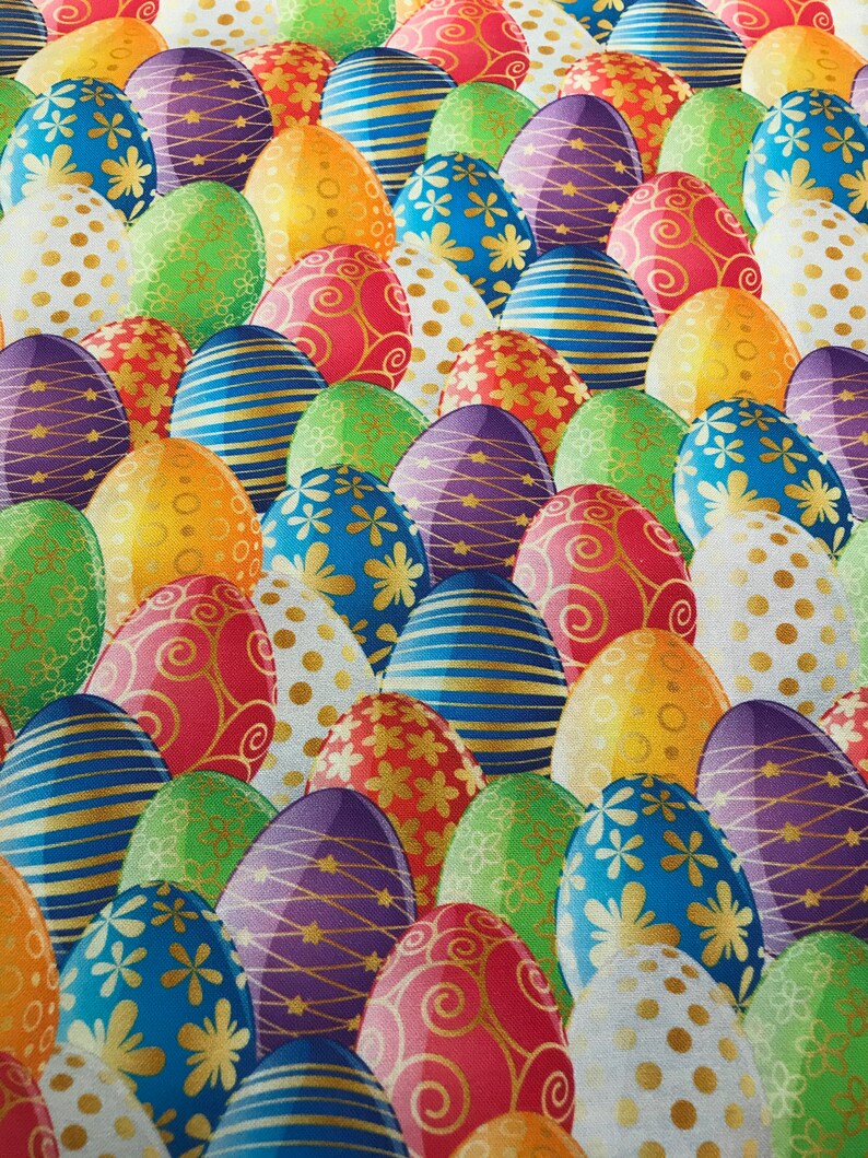May include: A colorful fabric with a repeating pattern of Easter eggs. The eggs are decorated with various designs, including polka dots, stripes, swirls, and flowers. The eggs are in shades of red, blue, green, yellow, purple, and white.