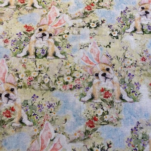 May include: A repeating pattern of white, brown, and pink bunny-eared puppies on a light blue and green floral background.