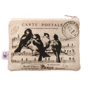 May include: A beige canvas zippered pouch with a vintage Parisian postcard design featuring a musical score, four birds, and the text "CARTE POSTALE" and "TOUR EIFFEL".