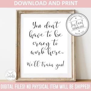 Op de afbeelding: Een ingelijste digitale print met de zwarte tekst: You don't have to be crazy to work here... We'll train you! Het ontwerp bevat een cirkelvormige badge in de rechterbovenhoek met de tekst Instant Download en een klein logo linksonder.