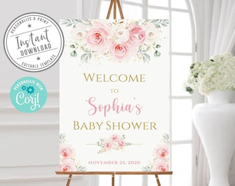 May include: A white baby shower welcome sign on a wooden easel featuring watercolor pink and white roses at the top and bottom. The text reads Welcome to Sophia's Baby Shower November 25, 2020 in gold and pink script and block lettering.