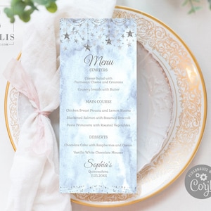 May include: A menu card with a light blue watercolor background, adorned with hanging stars and a decorative border. The menu lists starters, main courses, and desserts. The name "Sophia's" and the date "11.25.20XX" are also printed on the card.