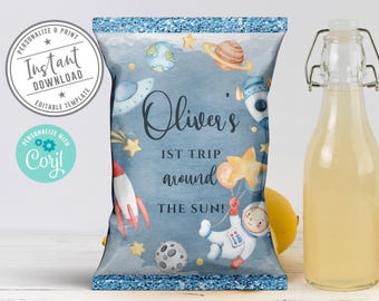 May include: A rectangular chip bag featuring a blue watercolor space theme with planets, stars, a rocket, and an astronaut holding a yellow star balloon. The text reads Oliver's 1ST TRIP AROUND THE SUN! The bag has a glittery blue top and bottom border.