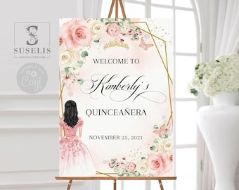 May include: A rectangular welcome sign for a Quinceañera featuring a pink and white floral arrangement, a gold geometric frame, a gold tiara, and an illustration of a person in a pink gown. Text reads: WELCOME TO Kimberly's QUINCEAÑERA NOVEMBER 25, 2021.