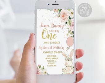 May include: A digital birthday invitation displayed on a smartphone screen featuring pink floral accents, a gold glitter number one, and a cartoon bunny. The text reads: Some Bunny is turning One, Join us to celebrate Sophia's 1st Birthday.