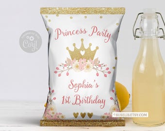 May include: A white chip bag with gold glitter borders, featuring a gold crown, pink floral accents, and the text Princess Party, Sophia's 1st Birthday. The design includes gold dots and three small gold hearts at the bottom center.