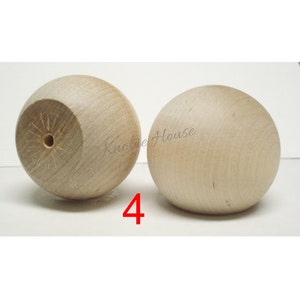 May include: Two wooden knobs, each with a smooth, round surface. The knobs are light brown in color and have a small hole in the center. The text "Knobie House" is visible in the background.