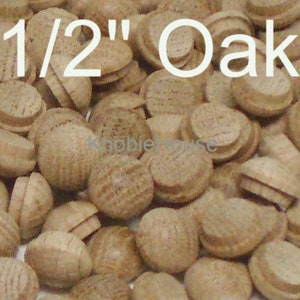 May include: A close-up image of a pile of 1/2 inch oak wood plugs. The plugs are a light brown color and have a smooth, rounded surface.