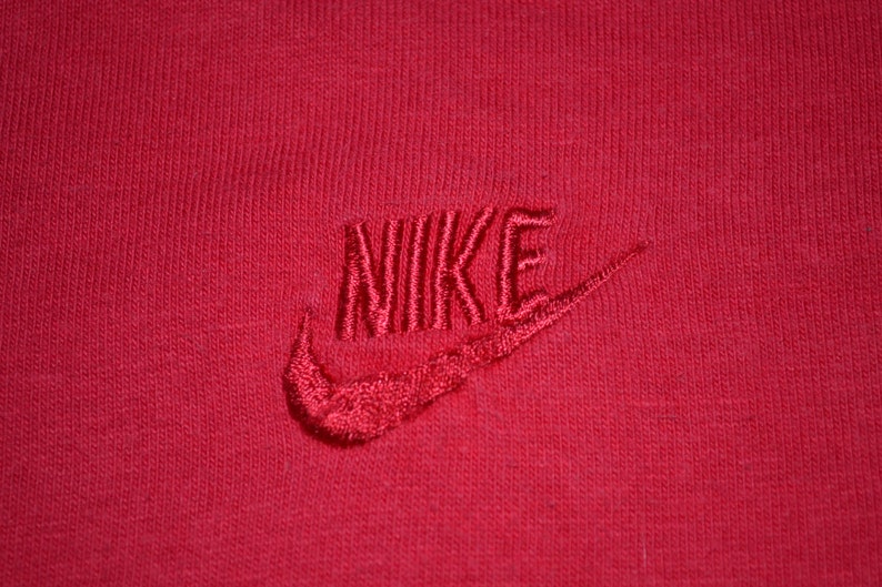 May include: Red t-shirt with a white embroidered Nike logo.