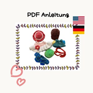 May include: A collection of crocheted items including a hat, dress, and accessories in various colors, including pink, red, green, blue, and brown. The items are arranged on a white background with a decorative border.