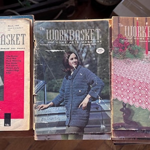 May include: Three vintage issues of "The Workbasket" magazine, featuring home and needlecraft projects. The covers display colorful designs and images, including a woman in a blue coat and a red and white tablecloth.