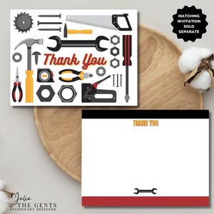 May include: A thank you card with a white background and a black border. The card features a variety of tools, including a hammer, wrench, screwdriver, saw, and nails. The text "Thank You" is written in red and yellow letters. The card also includes a separate white card with a black border and the text "Thank You" in yellow letters.