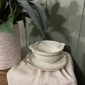 Vintage white and gold gravy boat with attached under plate