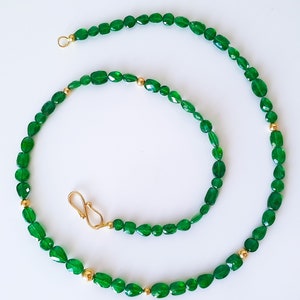 Pu&ograve; includere: Una collana di pietre preziose verdi con accenti dorati. La collana &egrave; realizzata con pietre verdi di forma ovale e perline dorate.