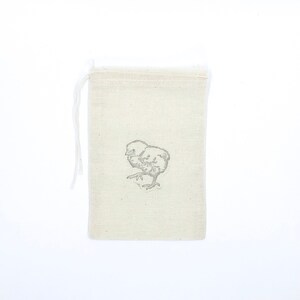 May include: A small, white cotton drawstring bag with a simple black and white illustration of a chick on the front.