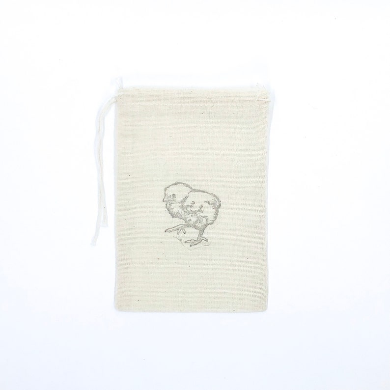 May include: A small, white cotton drawstring bag with a simple black and white illustration of a chick on the front.