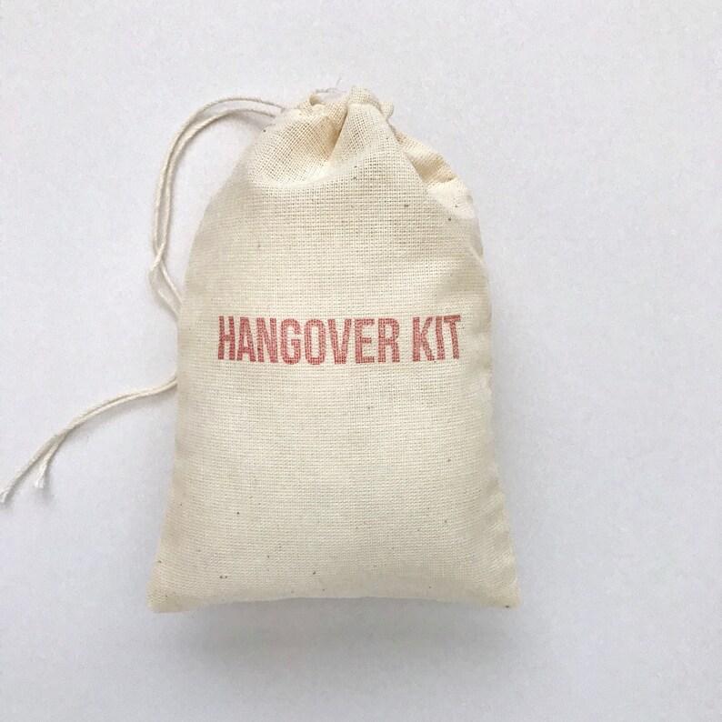May include: A small, white cotton drawstring bag with the words "HANGOVER KIT" printed in red on the front.