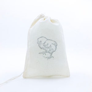 May include: A white cotton drawstring bag with a small grey chick illustration printed on the front.