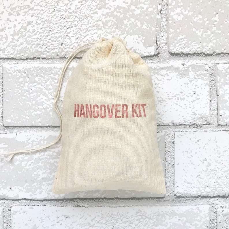 May include: A small, white cotton drawstring bag with the words "Hangover Kit" printed in red on the front.
