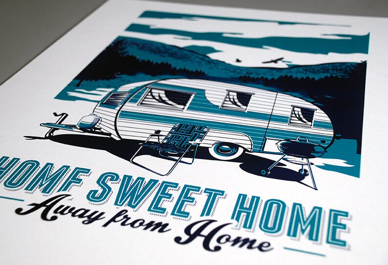 May include: A teal and white vintage camper trailer with a grill and chairs in front of it. The text "Home Sweet Home Away from Home" is printed below the camper.