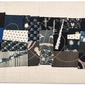May include: A patchwork quilt made of various blue and white fabrics with a swirling pattern of stitching. The quilt is made of different textures and patterns, including stripes, polka dots, and floral designs.